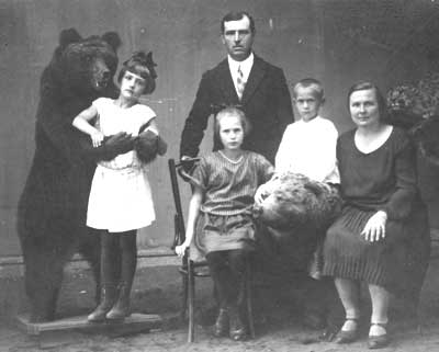Семья Анны Федоровны в 1930 году. Стоят Илья и рядом с ним сын Володя. В лапах у медведя младшая дочь Женя. Сидят Анна Федоровна и старшая дочь Ася 